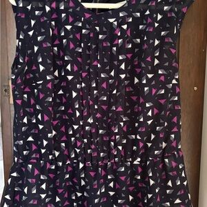Stylish sleeveless woman’s shell with black zipper and peplum